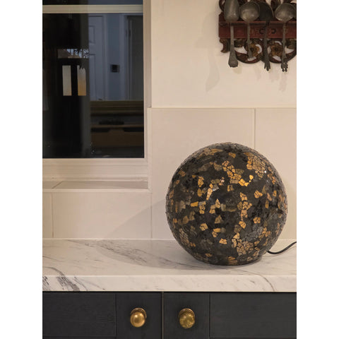 Decorative spherical lamp on a marble surface with a neutral wall background