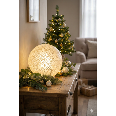 Decorative light on a wooden table with a Christmas tree in the background