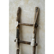 Collection of neutral hanging decor using shells, coconut wood and cotton.