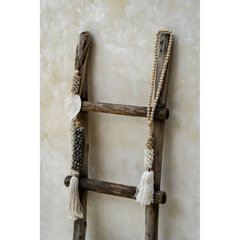 Collection of neutral hanging decor using shells, coconut wood and cotton.
