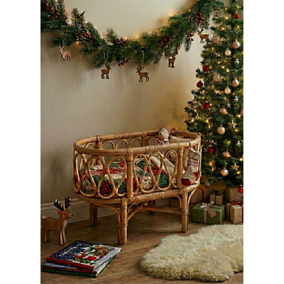 Nursery room decorated for Christmas with a crib, Christmas tree, and presents.