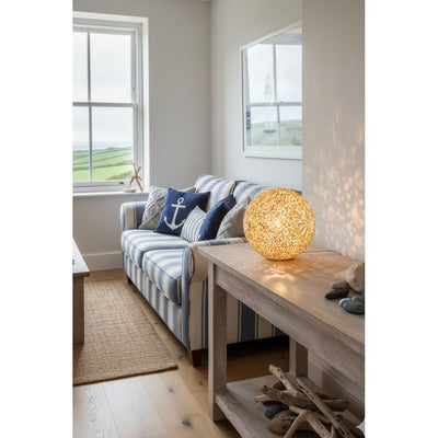 Living room with striped sofa, decorative pillows, and a textured shell lamp.