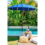 Front view of the Coastal Blue Balinese Garden Parasol with tassels and decorative brass charms.