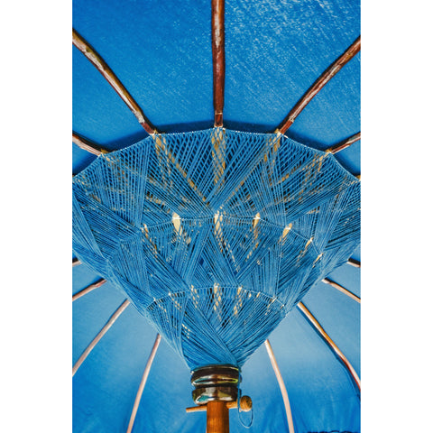 Macro shot of the handwoven blue threadwork at the center of the parasol, revealing Balinese craftsmanship.