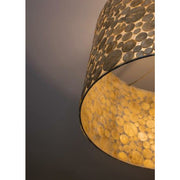 Close up shot of a lampshade covered in gold shell coins.