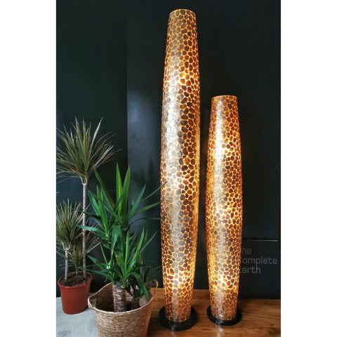 Gold floor lamps beside house plants. Pebble by Collectiviste lighting UK.