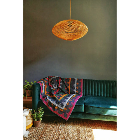 Rattan lampshade with light off in colourful living room setting. Handcrafted lighting by collectiviste.com