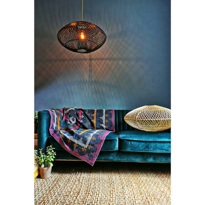 Modern black ceiling light over green sofa in grey living room. Natural lighting solutions by Collectiviste.