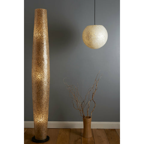 Extra tall gold floor lamp and white shell pendant against grey wall.