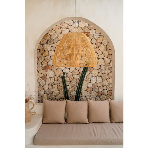 Large rattan pendant light hanging in neutral courtyard with cactus plant. Natural lighting by Collectiviste.