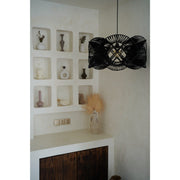 Black rattan lamp shade in white minimalist kitchen.