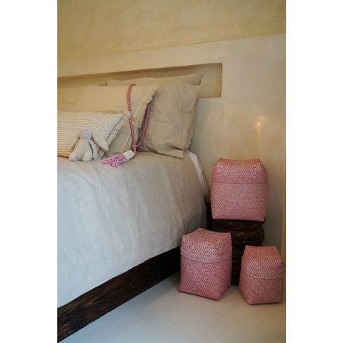 Handwoven pink nursery storage baskets in bedroom with bunny toy and wooden accessories. Decorative storage by Collectiviste.