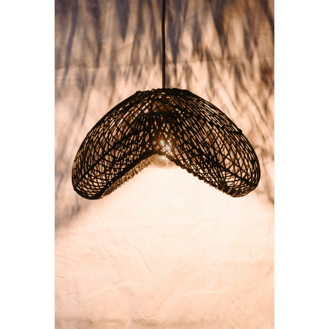 Black rattan ceiling light casting pretty patterns on white wall. Collectiviste lighting UK.