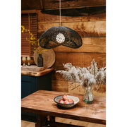 Black rattan lampshade over wooden dining table. Truffle rattan lampshade by Collectiviste lighting