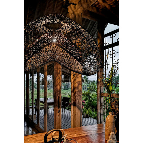 Tropical open living with stylish black rattan light shade by Collectiviste.