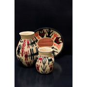 Trio of woven Werregue baskets and plates in natural palm with red and black indigenous motifs. Sold by Collectiviste UK.