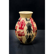 Natural wounaan basket with red and black design. 